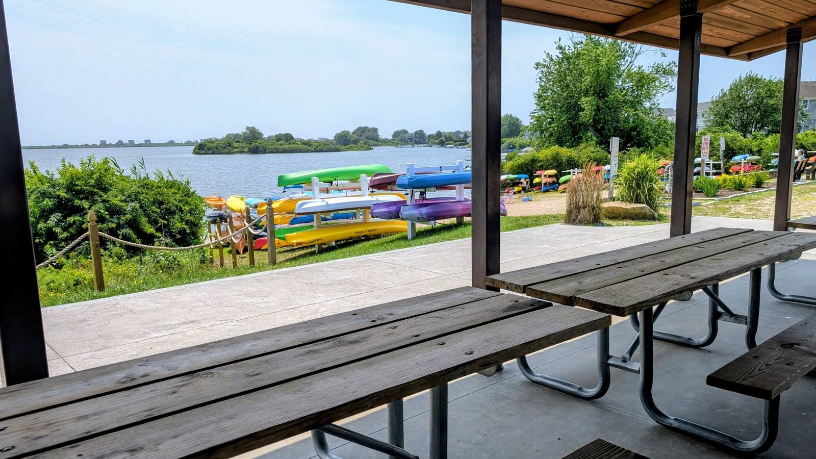 Private beach and kayaks viewed from the shaded picnic pavilion